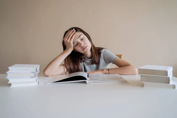 Cute teenager girl fell asleep on the books when she did her homework