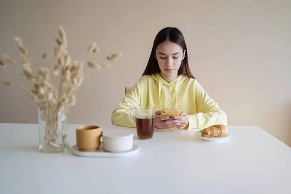 Roztomilé Teen Dívka Jíst Snídani Kuchyni Při Použití Její Chytrý — Stock fotografie