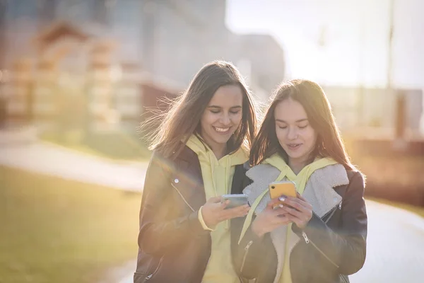Dwie Szczęśliwe Nastolatki Przyjaciół Korzystających Telefonu Komórkowego Podczas Odpoczynku Parku — Zdjęcie stockowe