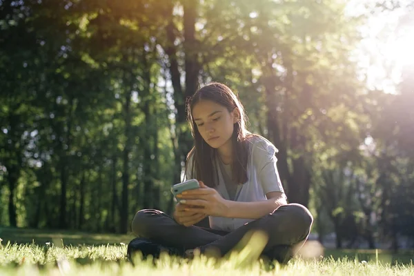 Nastolatka Siedząca Trawie Korzystająca Smartfona Parku — Zdjęcie stockowe
