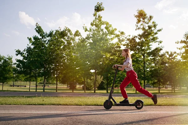 Gün Batımında Parkta Elektrikli Scooter Kullanan Tatlı Bir Genç Kız — Stok fotoğraf