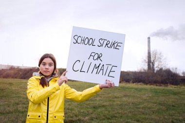                                Küresel iklim değişikliği grevi sırasında pankart tutan genç kız   