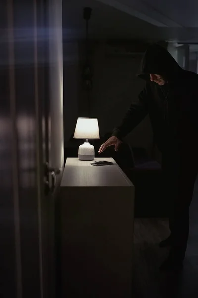 Robber in the hood inside the house at night