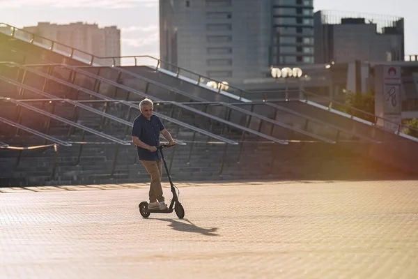 Hombre Mayor Montando Scooter Patada Eléctrica Paisaje Urbano Atardecer — Foto de Stock