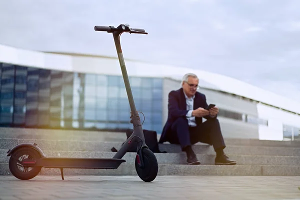 Senior Zakenman Met Behulp Van Telefoon Zijn Elektrische Scooter — Stockfoto