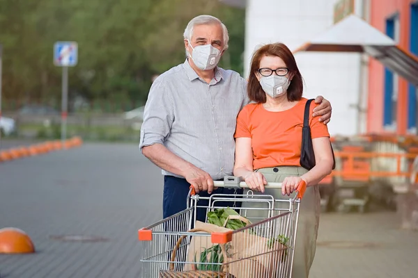 Portrait senior couple with face masks and shopping