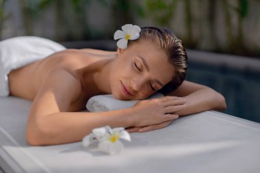 Güzel kız havuzun etrafında dinleniyor. Spa