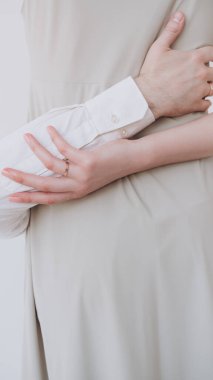 Parmağında yüzük olan bir kızın güzel eli bir erkeği kucaklıyor.