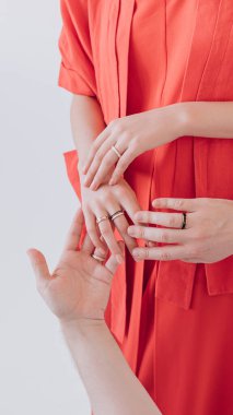 Kırmızı elbiseli parmağında yüzük olan güzel bir kız.