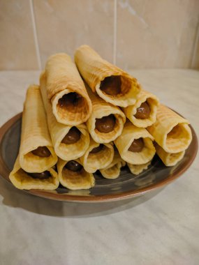 Bir tabakta yoğunlaştırılmış sütle waffle ruloları..