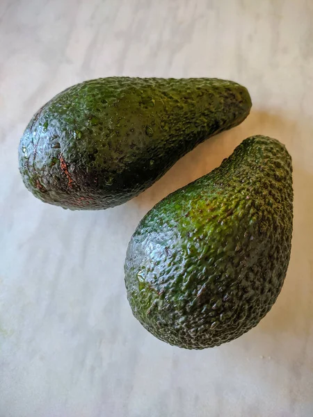 Zwei Grüne Avocados Auf Dem Tisch Nahaufnahme Hintergrund — Stockfoto