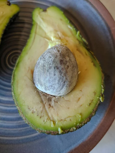 Zwei Hälften Grüne Avocado Mit Knochen Auf Einem Teller Nahaufnahme — Stockfoto