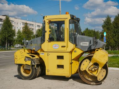Noyabrsk, Rusya - 9 Ağustos 2020: Traktör yolu paten pisti ile ASPHALT MANAGER sistemi kentteki bir otoparkta bulunmaktadır. Görünüm.