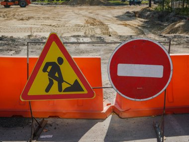 Bazı sarı plastik barikatlar trafik ve yol çalışmalarını yasaklayan işaretlerin arka planında yer alıyor. Yakın plan.