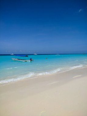 Zanzibar, Tanzanya - 3 Aralık 2019: Zanzibar 'daki Nungwi plajı, parlak mavi deniz ve güzel beyaz bir plajda mavi gökyüzü. Denizcilerin tekneleri balık tutmak ve dinlenmek için kıyıda. Harika bir cennet. Dikey.