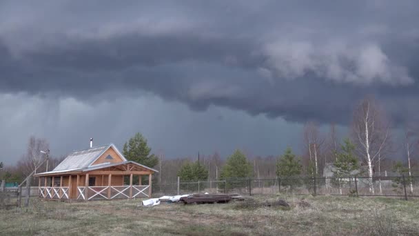 Черное голубое небо перед бурей. быстро летящие облака. Деревянный дом в лесу — стоковое видео