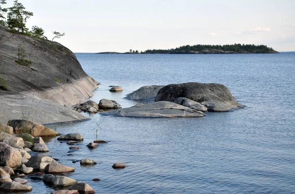 Ladoga Northen jezero s ostrovem na zadní straně a kamenné pobřeží. Obloha bez mraků — Stock fotografie