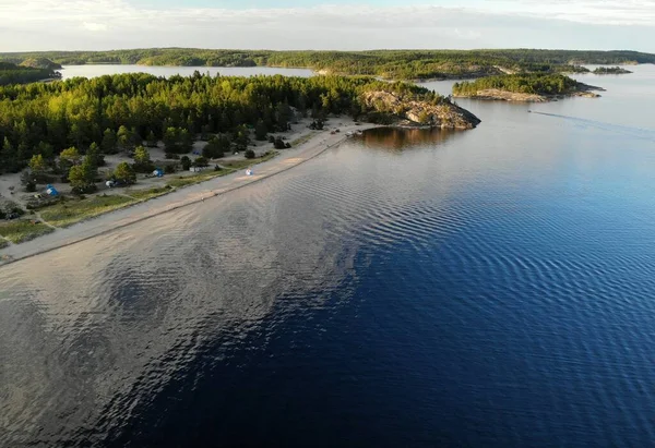 Ruská Karelia. Ladoga. Ostrov s dlouhou písečnou pláží se stany a stany. — Stock fotografie