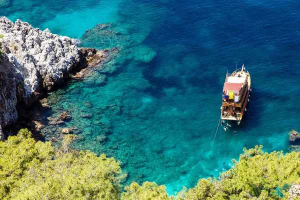 Turistler Akdeniz duru suları ile tekne. Üstten görünüm