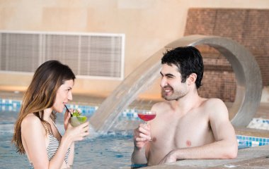 Güzel çift yüzme havuzunda kokteyl içme