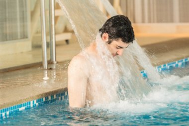 Yüzme havuzundaki yakışıklı adam.