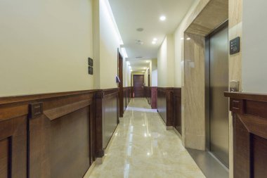 Mermer zeminli uzun otel koridoru