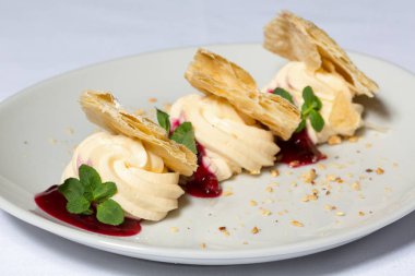 Beyaz tabakta servis edilen kremalı tatlı