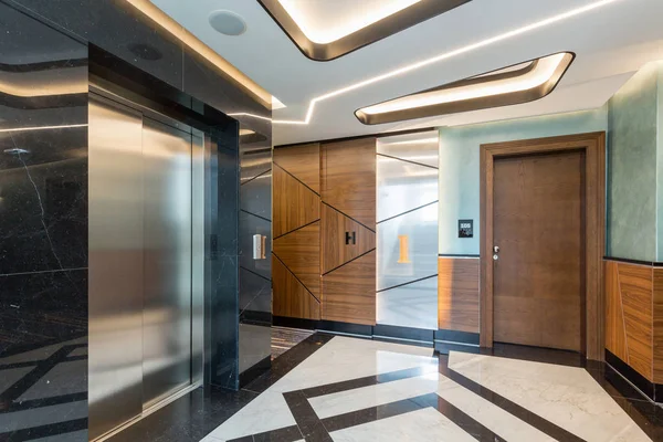 Interior of a shiny marble hotel corridor with elevator