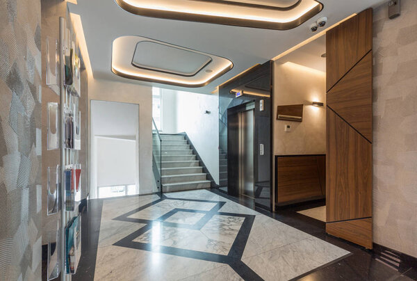 Интерьер мраморного коридора отеля с лифтом
