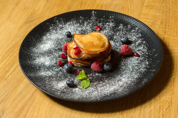 Panqueques pequeños con fruta servida en el plato — Foto de Stock