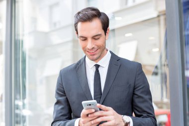 Cep telefonuna bakan çekici genç adam