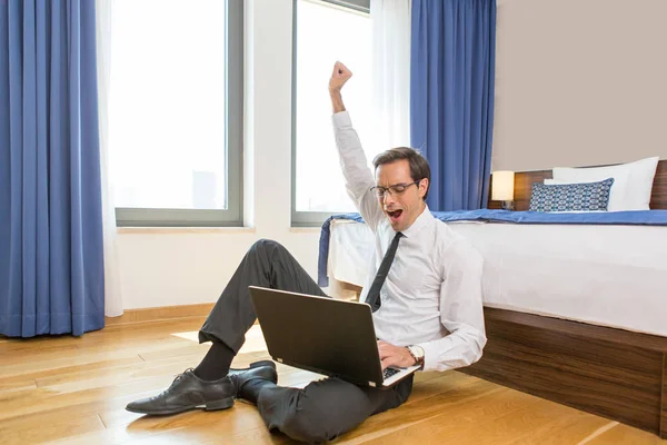 Succes, goed nieuws, zakenman vieren in een hotelkamer — Stockfoto