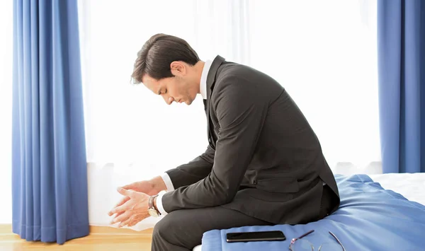 Frustrated businessman sitting on the hotel bed — Stock Photo, Image