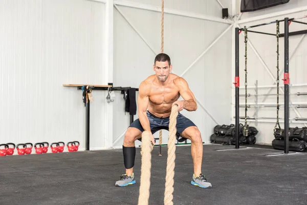 Homens com cordas de batalha exercitam-se no ginásio de fitness. CrossFit conc — Fotografia de Stock