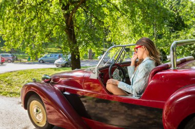 Üstü açık arabada poz veren çekici moda kadınları.