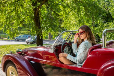 Üstü açık arabada poz veren çekici moda kadınları.