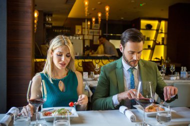 Mutsuz çift restoranda yemek yiyor. 