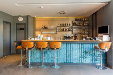 Kafenin iç kısmında sandalyeler olan mavi bar tezgahı.