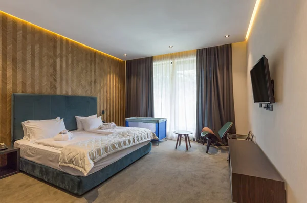 İçinde bebek karyolası olan bir otel odası.