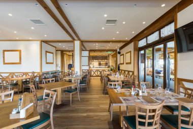 Ahşap mobilyalı bir otel restoranının içinde.