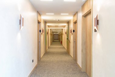 Uzun bir otel koridorunun içinde.