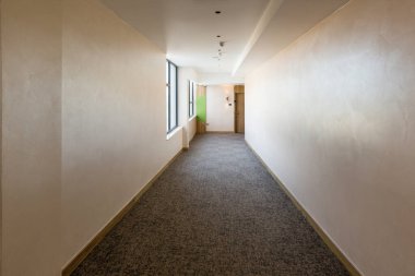 Uzun bir otel koridorunun içinde.