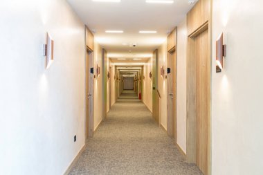 Uzun bir otel koridorunun içinde.