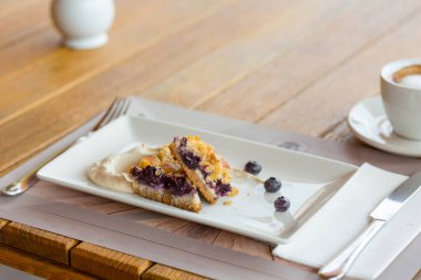 Beyaz tabakta servis edilen meyveli tatlı.