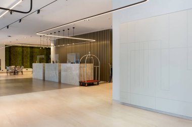 Şeffaf pleksiglas Lexan hapşırık korumalı resepsiyonlu bir otel lobisi.