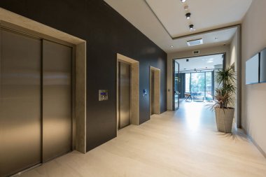 Asansör kapısı olan otel lobisi.