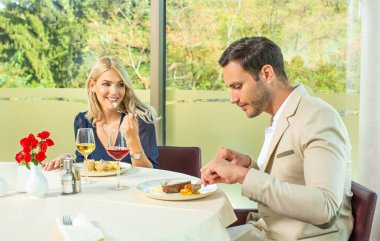 Çekici bir çift otel restoranında yemek yiyor.