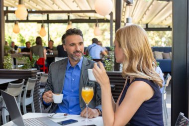 Kafe barında iş arkadaşları konuşuyor ve kahve içiyor.