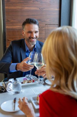 Çekici bir çift otel restoranında kadeh kaldırıyor.