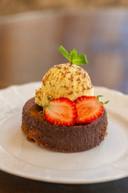 Lokantada beyaz bir tabakta servis edilen meyveli pasta.